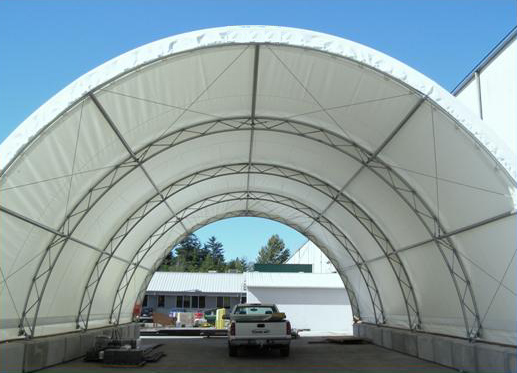 Tension fabric structure, arch style fabric building used for steel storage.