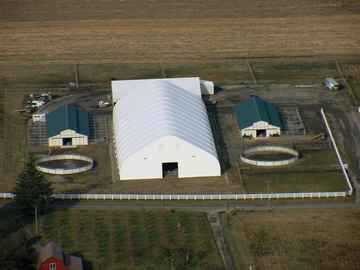 Tension fabric structure, peak style fabric building used for indoor riding arena.